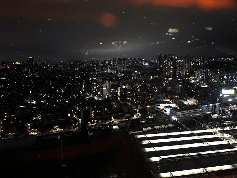 The night landscape around seoul that took from high floor through the window. There are some platform lights of the Seoul station front of the picture, high buildings are spread to the horizon
